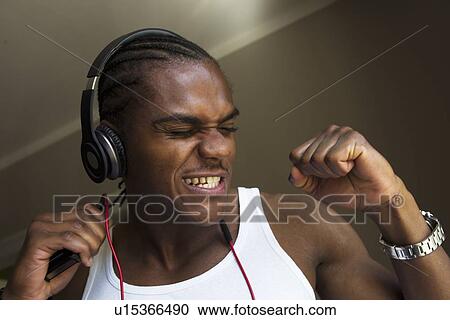 Smiling man singing with headphones View Large Photo Image Stock Image - Smiling man singing with headphones. Fotosearch