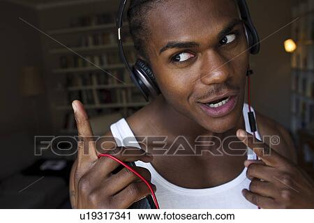 Smiling man singing with headphones View Large Photo Image Stock Image - Smiling man singing with headphones. Fotosearch
