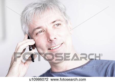 Smiling man talking on cell phone View Large Photo Image Stock Image - Smiling man talking on cell phone. Fotosearch