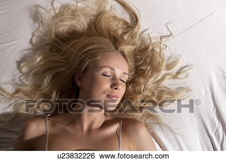 Stock Photograph - Smiling woman asleep in bed. Fotosearch