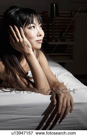 Smiling woman laying on bed View Large Photo Image Stock Photo - Smiling woman laying on bed. Fotosearch