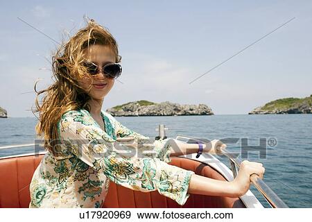 Smiling woman riding on boat View Large Photo Image Stock Photo - Smiling woman riding on boat. Fotosearch