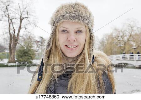 Stock Image - Smiling woman wearing fur hat. Fotosearch