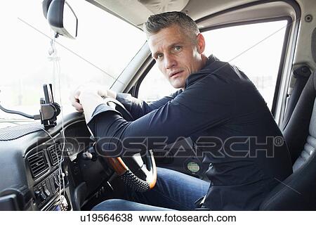 Taxi driver sitting at steering wheel View Large Photo Image Stock Photo - Taxi driver sitting at steering wheel. Fotosearch