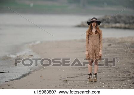 Teenage girl standing on sandy beach View Large Photo Image Stock Photo - Teenage girl standing on sandy beach. Fotosearch