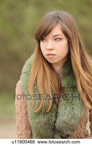 Stock Photo - Teenage girl wearing fur scarf outdoors. Fotosearch