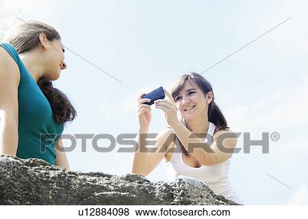 Teenage girls taking pictures outdoors View Large Photo Image Stock Photo - Teenage girls taking pictures outdoors. Fotosearch