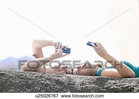 Teenage girls using cell phones outdoors View Large Photo Image Stock Photo - Teenage girls using cell phones outdoors. Fotosearch
