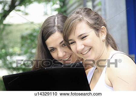 Teenage girls using laptop together View Large Photo Image Stock Image - Teenage girls using laptop together. Fotosearch