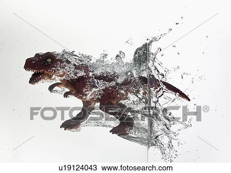 Stock Image - Toy dinosaur plunging into water. Fotosearch