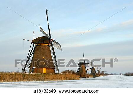 Windmills by frozen rural lake View Large Photo Image Stock Photo - Windmills by frozen rural lake. Fotosearch
