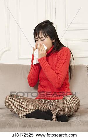 Woman blowing her nose on couch View Large Photo Image Stock Photography - Woman blowing her nose on couch. Fotosearch