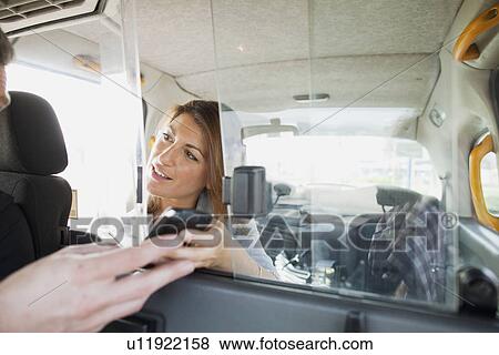 Woman handing cell phone to taxi driver View Large Photo Image Stock Photo - Woman handing cell phone to taxi driver. Fotosearch