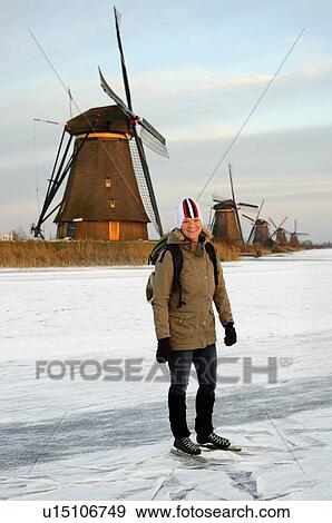 Stock Photo - Woman skating on frozen rural lake. Fotosearch