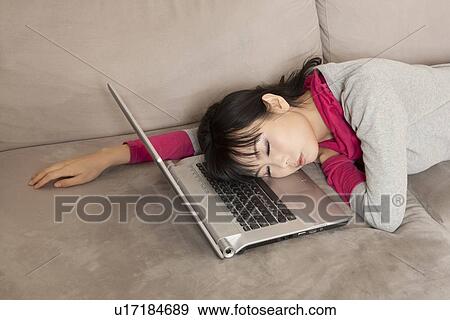 Stock Photo - Woman sleeping on laptop on couch. Fotosearch