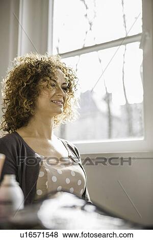 Stock Photo - Woman smiling at window. Fotosearch