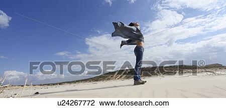 Woman standing on windy beach View Large Photo Image Stock Image - Woman standing on windy beach. Fotosearch