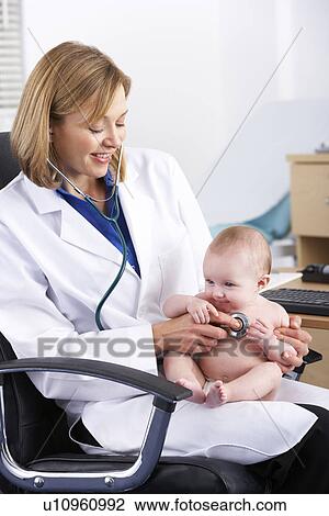Stock Image - American doctor examining baby. Fotosearch