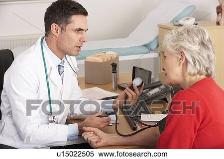 Stock Photography - American doctor taking senior woman's blood pressure. Fotosearch