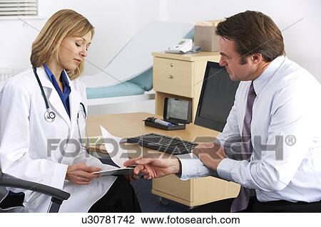 Stock Image - American doctor talking to businessman patient. Fotosearch