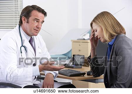 Stock Image - American doctor talking to depressed businesswoman. Fotosearch