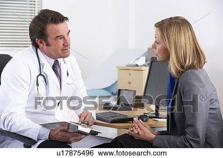 Stock Photograph - American doctor talking to businesswoman patient. Fotosearch