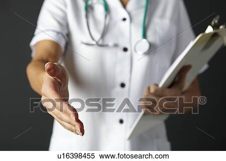 Stock Photography - American nurse extending hand to shake. Fotosearch