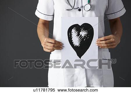 Stock Photography - American nurse holding ink drawing of heart. Fotosearch