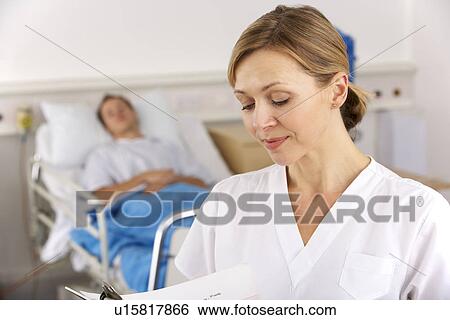 Stock Photograph - American nurse working on hospital ward. Fotosearch