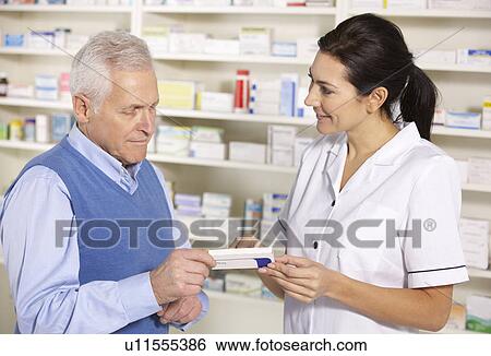 American pharmacist serving senior man in pharmacy View Large Photo Image Stock Photograph - American pharmacist serving senior man in pharmacy. Fotosearch