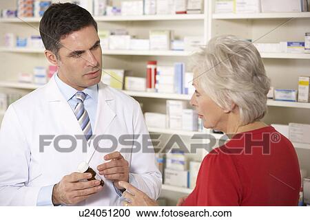 American pharmacist with senior woman in pharmacy View Large Photo Image Stock Image - American pharmacist with senior woman in pharmacy. Fotosearch