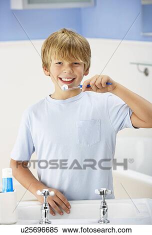 Stock Photography - Boy cleaning teeth in bathroom. Fotosearch