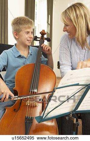 Boy playing cello in music lesson View Large Photo Image Stock Photography - Boy playing cello in music lesson. Fotosearch