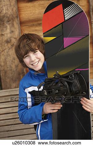Boy With Snowboard On Ski Holiday In Front Of Wooden Background View Large Photo Image Stock Photo - Boy With Snowboard On Ski Holiday In Front Of Wooden Background. Fotosearch