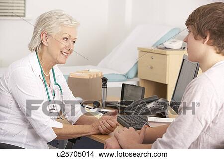 British GP talking to young male patient View Large Photo Image Picture - British GP talking to young male patient. Fotosearch