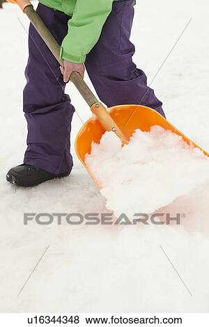 Stock Photo - Close Up Of Teenage Boy Shovelling Snow From Path. Fotosearch