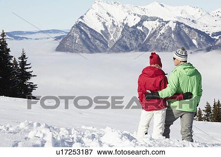 Couple Admiring Mountain View Whilst On Ski Holiday In Mountains View Large Photo Image Stock Photo - Couple Admiring Mountain View Whilst On Ski Holiday In Mountains. Fotosearch