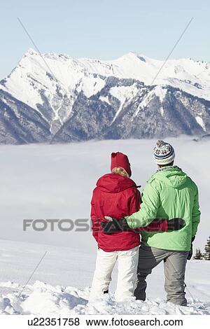 Couple Admiring Mountain View Whilst On Ski Holiday In Mountains View Large Photo Image Stock Photo - Couple Admiring Mountain View Whilst On Ski Holiday In Mountains. Fotosearch