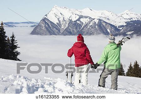 Couple Admiring Mountain View Whilst On Ski Holiday In Mountains View Large Photo Image Stock Photography - Couple Admiring Mountain View Whilst On Ski Holiday In Mountains. Fotosearch