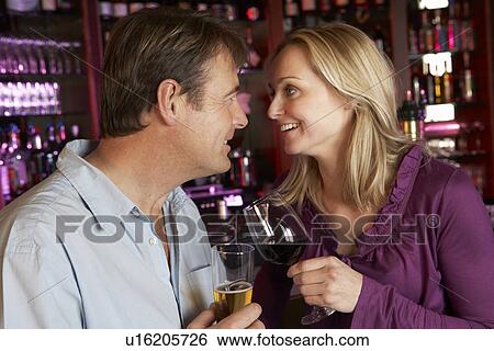 Stock Photograph - Couple Enjoying Drink Together In Bar. Fotosearch