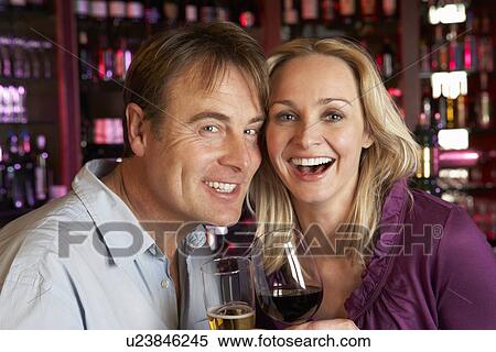 Stock Photography - Couple Enjoying Drink Together In Bar. Fotosearch