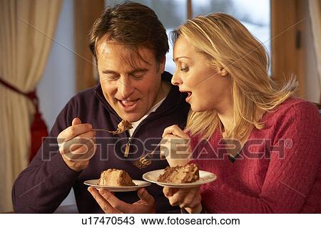 Couple Enjoying Slice Of Cake Sitting On Sofa View Large Photo Image Stock Image - Couple Enjoying Slice Of Cake Sitting On Sofa. Fotosearch