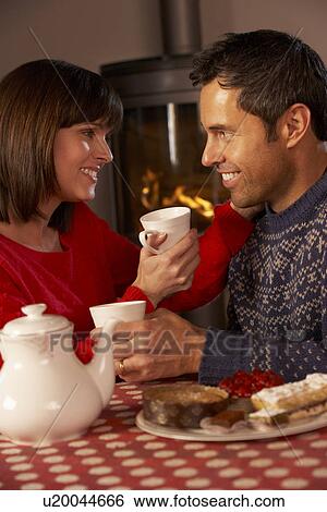 Couple Enjoying Tea And Cake By Cosy Log Fire View Large Photo Image Stock Photograph - Couple Enjoying Tea And Cake By Cosy Log Fire. Fotosearch