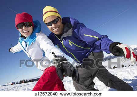 Stock Image - Couple Having Fun On Ski Holiday In Mountains. Fotosearch