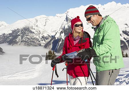 Couple Looking At Map Whilst On Ski Holiday In Mountains View Large Photo Image Picture - Couple Looking At Map Whilst On Ski Holiday In Mountains. Fotosearch