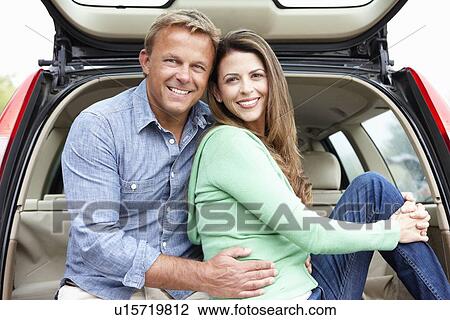 Stock Image - Couple outdoors with car. Fotosearch