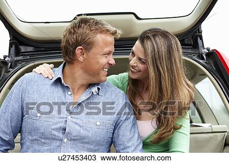 Stock Image - Couple outdoors with car. Fotosearch