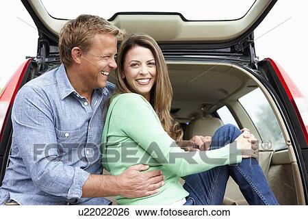 Couple outdoors with car View Large Photo Image Stock Photograph - Couple outdoors with car. Fotosearch