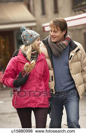 Couple Walking Along Snowy Town Street In Ski Resort View Large Photo Image Stock Photo - Couple Walking Along Snowy Town Street In Ski Resort. Fotosearch