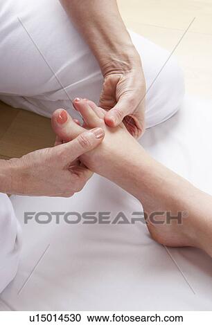 Stock Image - Detail foot reflexology massage. Fotosearch